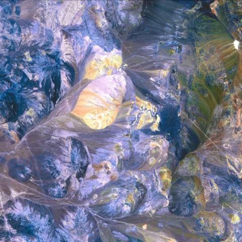 Satellite image of the Atacama Desert, Antofagasta, Chile: sharp reliefs in muted shades of blue, yellow, pink, green, and brown