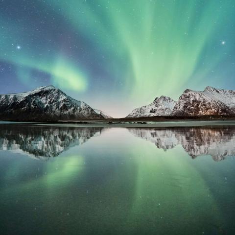 The northern lights with shadows of green and blue, reflected in a lake
